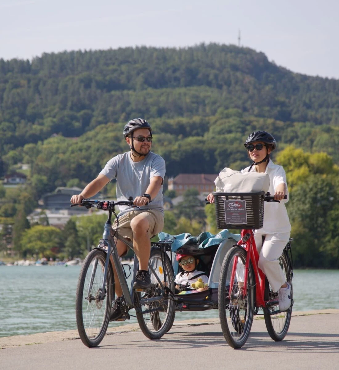 Famille avec un vélo et vélo cargo loués à Annecy chez Roul'ma poule