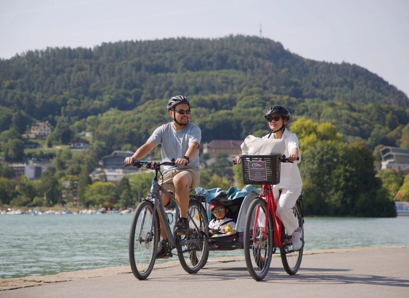 Famille avec un vélo et vélo cargo loués à Annecy chez Roul'ma poule
